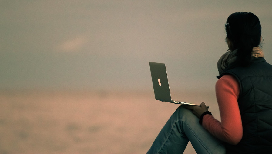 Let health come to you A woman gets a telehealth session while sitting in the wilderness.